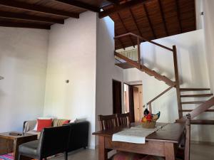a dining room with a wooden table and a staircase at Costanera 61, frente a la laguna in Chascomús