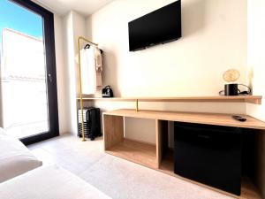 a living room with a tv on the wall at Hugo Beach Hotel & Apartments in Gandía