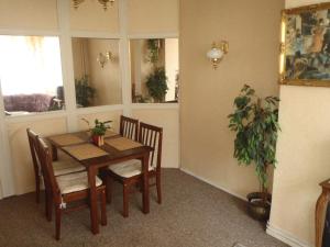 ein Esszimmer mit einem Tisch, Stühlen und einer Pflanze in der Unterkunft Hotel Green House in Teplice