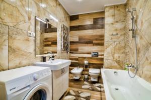 uma casa de banho com uma máquina de lavar roupa e um lavatório em LEOGRAND Apartments z Panoramoyu Lvova em Lviv