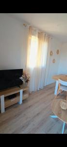 a living room with a flat screen tv and a table at Residence Mara Dea in Galeria