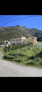 a building on the side of a hill with flowers at Residence Mara Dea in Galeria