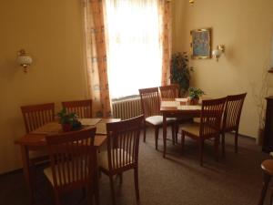 un comedor con mesas y sillas de madera y una ventana en Hotel Green House en Teplice