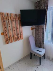 a chair sitting in a room with a flat screen tv at Mountain Breeze in Borlova +6 photos