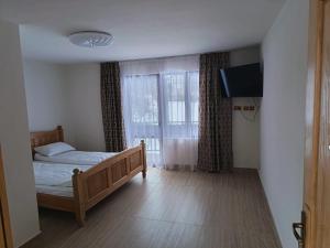 a bedroom with a bed and a large window at Mountain Breeze in Borlova