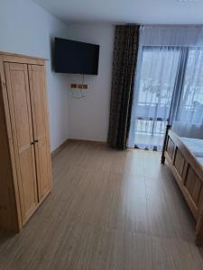 a room with a bed and a tv on a wall at Mountain Breeze in Borlova