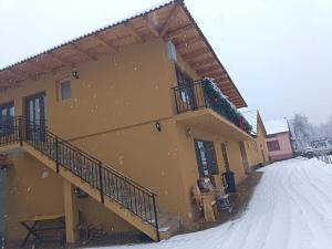 a building with snow falling on the side of it at Mountain Breeze in Borlova