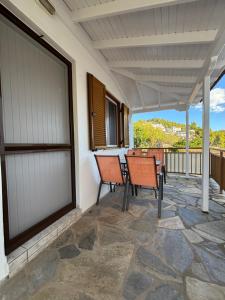 a porch with two chairs and a table at MARIA 'S LITTLE HOUSE in Patitiri