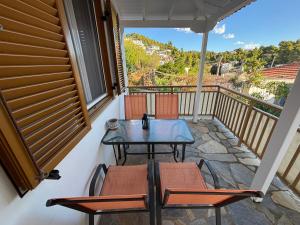 a patio with a table and chairs on a balcony at MARIA 'S LITTLE HOUSE in Patitiri +9 photos