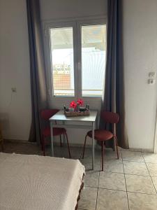 a room with a table and two chairs and a window at MARIA 'S LITTLE HOUSE in Patitiri
