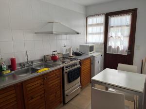 a kitchen with a sink and a stove top oven at Costanera 61, frente a la laguna in Chascomús +19 photos