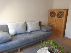 a couch with three pillows in a living room at Lottes FeWo in Hasselroth