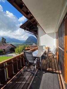 a wooden deck with a table and chairs on it at Sunshine Lodge in Pfronten