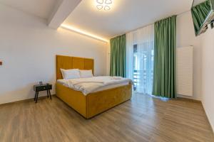 a bedroom with a bed and green curtains at Forever young Bran in Sohodol