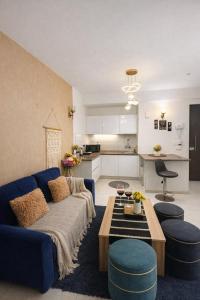 a living room with a blue couch and a table at Warm Embrace in Noida