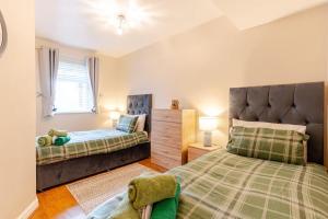 a bedroom with two beds and a window at Acorns in Holywell