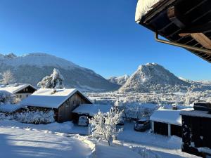 a village covered in snow with mountains in the background at Sunshine Lodge in Pfronten +1 photo