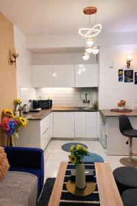 a kitchen with white cabinets and a table in a room at Warm Embrace in Noida