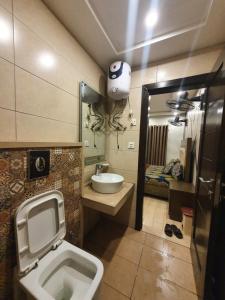 a bathroom with a toilet and a sink and a mirror at Sunset heaven in Lahore