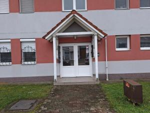 a red and white building with a white door at Benett Apartman in Győr