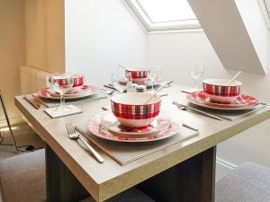 a table with red and white plates and wine glasses at Palace View - Uk40569 in Falkland