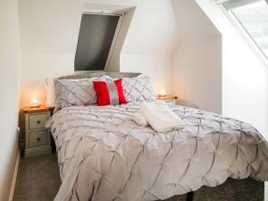 a bedroom with a bed with red and white pillows at Palace View - Uk40569 in Falkland +13 photos