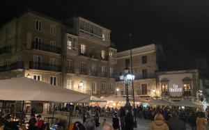 a crowd of people walking around a street at night at San VICENTE in Vigo