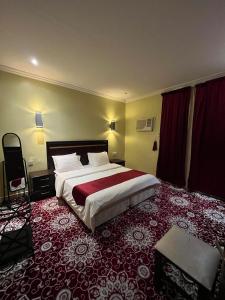 a bedroom with a large bed with a red carpet at شقق دازللشقق المخدومة in Hail