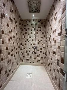 a bathroom with a shower with tiled walls at شقق دازللشقق المخدومة in Hail +27 photos