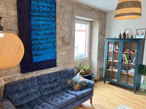 a living room with a blue couch and a book shelf at Hideaway Galicia Corrubedo in Corrubedo