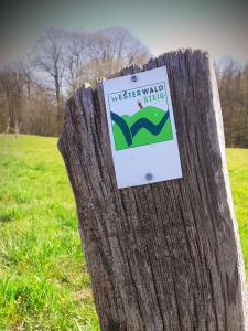 a sign on a wooden post in a field at Landhotel Marienthaler Hof in Marienthal