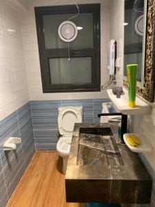 a bathroom with a white toilet and a window at Clouds chase in Madinaty