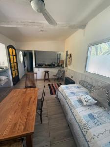 a bedroom with a bed and a table and a kitchen at Resolana y Rinconada in Isla del Rincón