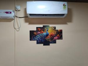 a peacock painting on a wall next to a printer at Aagman Homestay in Srīvardhan