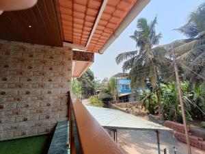 a balcony with a view of the beach and palm trees at Aagman Homestay in Srīvardhan