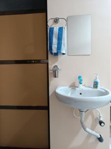 a bathroom with a sink next to a refrigerator at Aagman Homestay in Srīvardhan