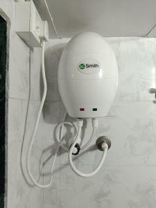 a white shower head on a wall in a bathroom at Aagman Homestay in Srīvardhan +67 photos