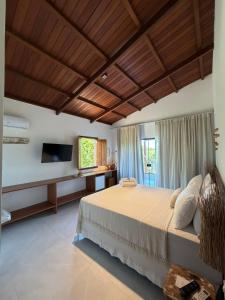 a bedroom with a large bed and a television at Pousada Almaré Boipeba in Ilha de Boipeba