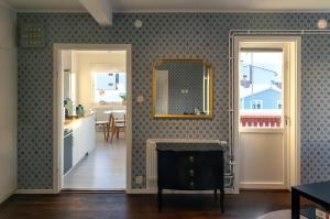 a living room with a mirror on the wall and a kitchen at Lugnt läge i centrala Rättvik in Rättvik