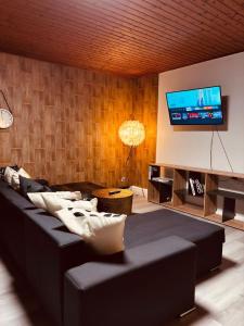 a living room with a black couch and a flat screen tv at Bad Rothenfelde Residence in Bad Rothenfelde