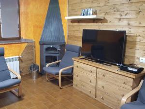 sala de estar con TV de pantalla plana y chimenea en Casa de Aldea El Sol, en Poo de Cabrales