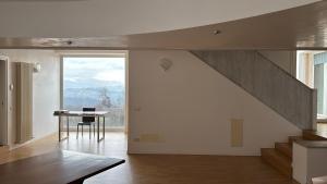 a living room with a staircase and a table with a laptop at Nuovo Progetto A&E in Vicenza