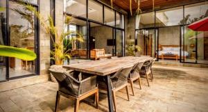 a large dining room with a wooden table and chairs at Pigstone Design Studios Beachfront in Tanah Lot
