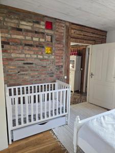 a baby crib in a room with a brick wall at Suur-Veski apartment in Pärnu
