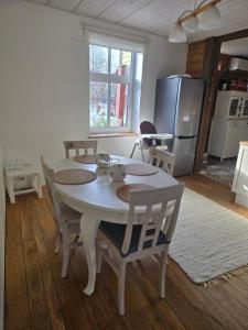 a kitchen with a table and chairs and a refrigerator at Suur-Veski apartment in Pärnu +12 photos