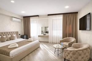 a bedroom with a large bed and two chairs at Royal Renaissance Boutique by IGIT in Yerevan