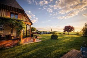 a house with a grass yard next to a building at Chambre privée, A l'ombre des Pommiers in Croix-Mare