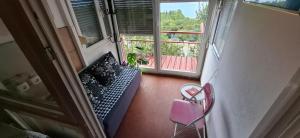 a balcony with a pink chair and a window at Apartman Lea in Crikvenica