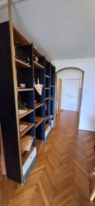 a room with a closet with wooden shelves and a door at Apartman Lea in Crikvenica