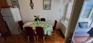 a dining room table with a vase of flowers on it at Apartman Lea in Crikvenica